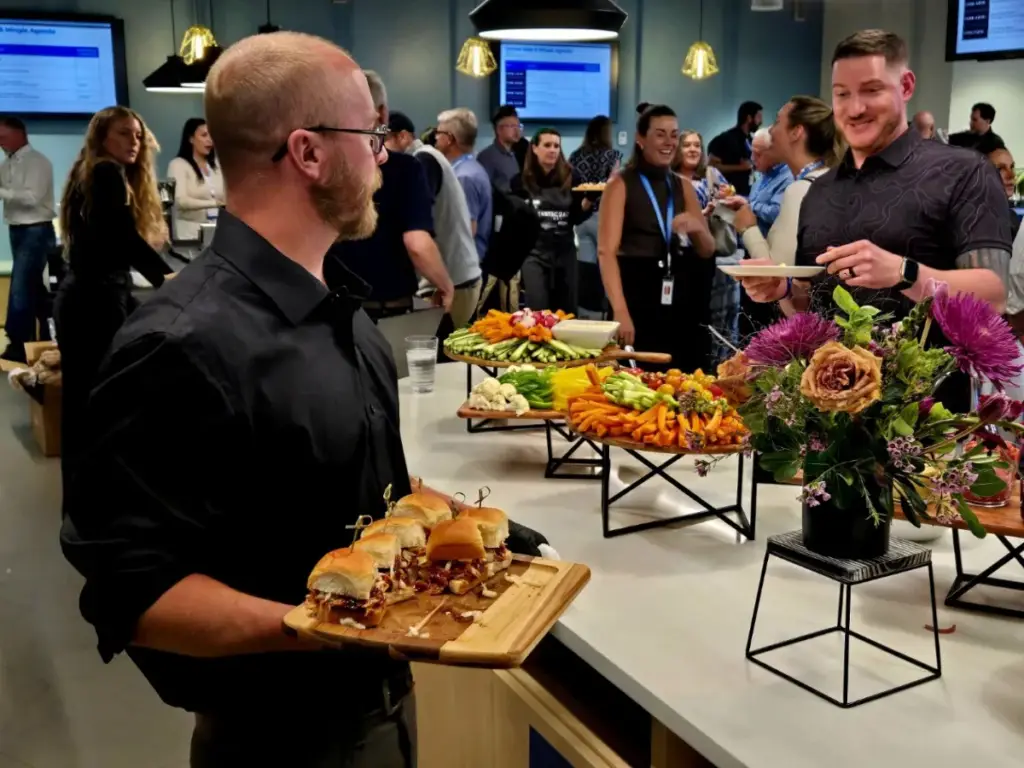 Server presenting an appetizer board at a corporate dining event
